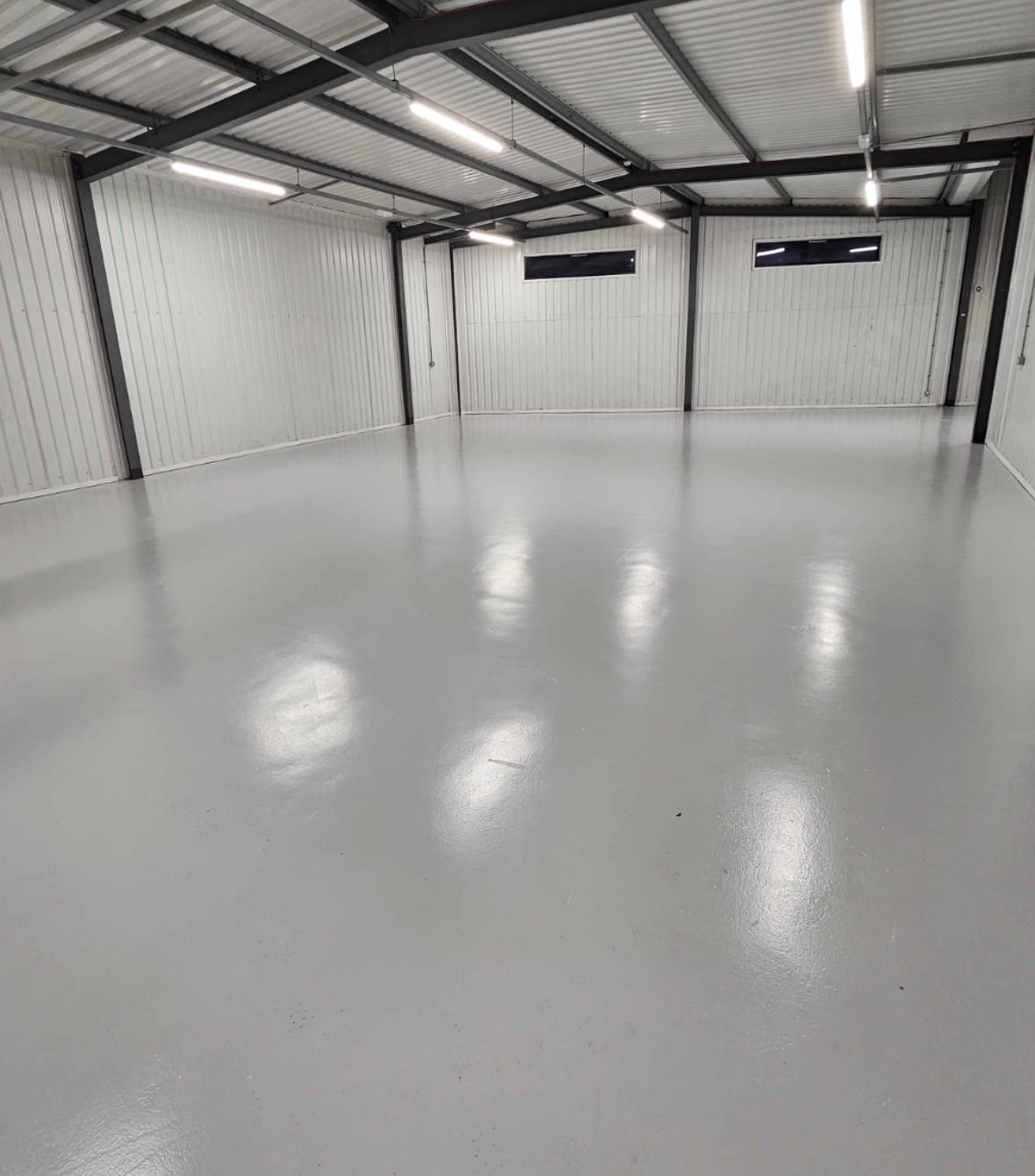 A smooth grey resin floor in an empty industrial unit
